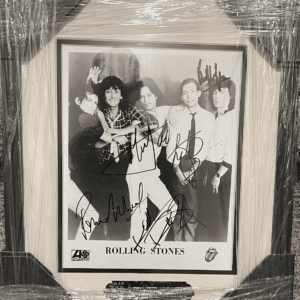 Framed autographed photo of a rock band.